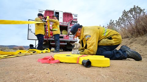 Firefighters prepare hoses to fight the Fairview Fire inside the San Bernardino National Forest near Hemet, California on September 9, 2022. - The wildfire burning outside Los Angeles has doubled in size in less than 24 hours, firefighters said on September 8 as they endured yet another day of blistering heat in the western US. Thousands of people have been told to evacuate in the face of the growing fire, which has now spread to 19,000 acres (7,700 hectares). (Photo by Frederic J. BROWN / AFP) (Photo by FREDERIC J. BROWN/AFP via Getty Images)