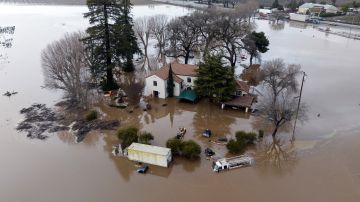 This aerial view shows a flooded home partially underwater in Gilroy, California, on January 9, 2023. - A massive storm called a bomb cyclone" by meteorologists has arrived and is expected to cause widespread flooding throughout the state. (Photo by JOSH EDELSON / AFP) (Photo by JOSH EDELSON/AFP via Getty Images)
