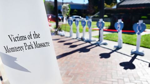 A man writes a message on a cross, one of 11 displayed for the victims killed late on January 21, outside City Hall in Monterey Park, California on January 24, 2023 at a makeshift memorial of flowers, candles and balloons. - Huu Can Tran, the 72-year-old Asian immigrant who killed 11 people before shooting himself as police moved in on him was once a regular at the California dance club where a tragic gun massacre unfolded as people celebrated the lunar new year. Tran used a semi-automatic pistol to spray 42 bullets around the Star Ballroom Dance Studio in Monterey Park, an Asian-majority city near Los Angeles. (Photo by Frederic J. BROWN / AFP) (Photo by FREDERIC J. BROWN/AFP via Getty Images)