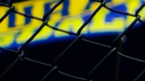Hincha de Boca Juniors subido a una cerca en el Estadio de La Bombonera
