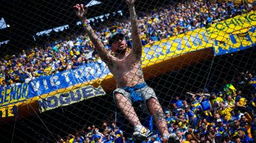 Hincha de Boca Juniors subido a una cerca en el Estadio de La Bombonera