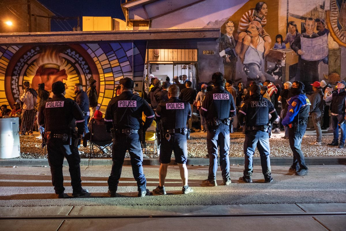 Policías vigilan a inmigrantes entrando a un refugio en El Paso en enero de 2023.