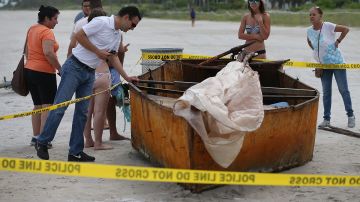 Curiosos rodean un bote usado por inmigrantes cubanos para llegar a las costas de Florida, en una foto de archivo.
