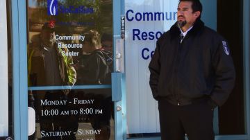 A security guard stands in position as Porter Ranch residents, seen reflected on the glass door, await entry to the SoCal Gas Community Resource Center in Porter Ranch, California on January 8, 2016, where residents have been going to lodge complaints and seek an alternative housing situation from their homes near where natural gas leaking from a well has sickened and displaced thousands of residents. More than 1,600 odor complaints have been lodged by residents with the air district since October 23, 2015 when the leak began. Repeated efforts to stop the leak by pumping liquid and mud down the well have failed and the gas company is now drilling a relief well to intercept and plug the damaged well.AFP PHOTO/FREDERIC J. BROWN / AFP / FREDERIC J. BROWN (Photo credit should read FREDERIC J. BROWN/AFP via Getty Images)