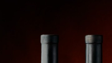 Imagen de varias botellas de vidrio de cerveza y de vino, además de una copa y un tarro.