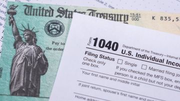 Imagen de un formulario 1040 para la declaración de impuestos 2023, junto con un cheque de reembolso.