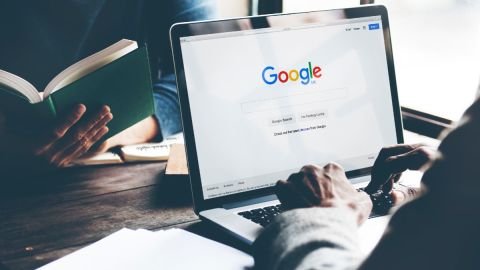 Imagen de una computadora con el logotipo de la empresa Google y de personas trabajando.