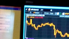 Imagen de una persona que mira monitores con indicadores bursátiles.