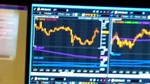 Imagen de una persona que mira monitores con indicadores bursátiles.