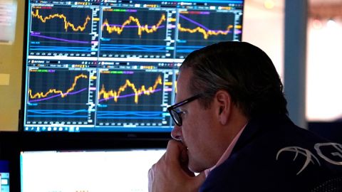 Imagen de una persona que mira monitores con indicadores bursátiles.