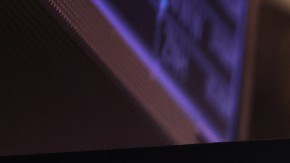 Imagen de una persona fuera de foco en el piso de remates de Wall Street, en el que se ven varias pantallas con indicadores.