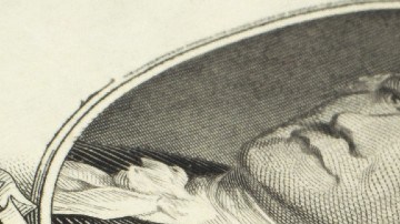 Imagen de un billete de $20 dólares, una pluma y varias tarjetas.