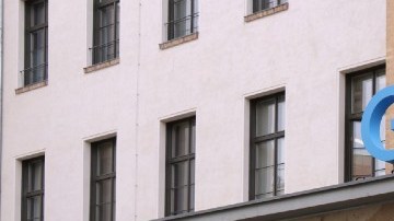 Imagen de un edificio de oficinas de Google con una bicicleta de remolque afuera y un logotipo de un servicio de nube.