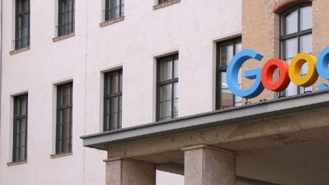 Imagen de un edificio de oficinas de Google con una bicicleta de remolque afuera y un logotipo de un servicio de nube.