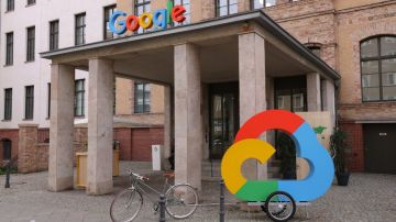 Imagen de un edificio de oficinas de Google con una bicicleta de remolque afuera y un logotipo de un servicio de nube.