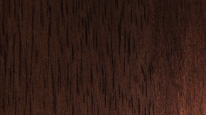 Imagen de un llavero con una llave de color plata, sobre una base de madera.