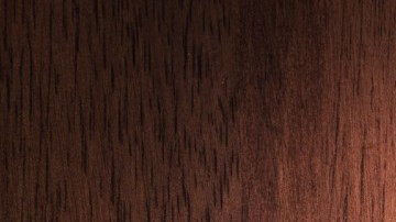 Imagen de un llavero con una llave de color plata, sobre una base de madera.