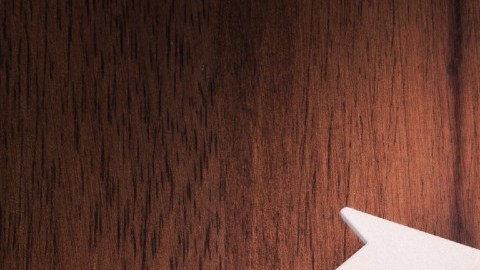 Imagen de un llavero con una llave de color plata, sobre una base de madera.