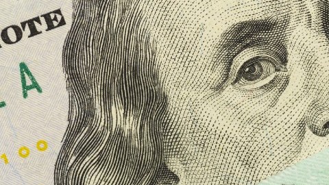 Imagen de un formulario de impuestos 1040, de un cheque de reembolso de impuestos y de un billete de $100 dólares.