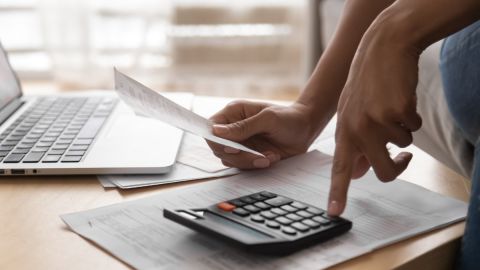 Una persona usa una calculadora mientras prepara sus impuestos.