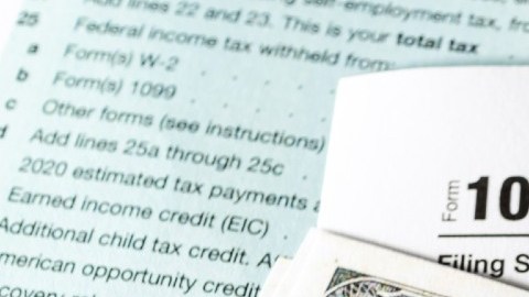 Imagen de un cheque de reembolso de impuestos, un billete de $100 dólares y un formulario 1040.