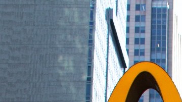 Imagen del logotipo de la cadena de restaurantes de comida rápida McDonald's, sujeta a un muro de cristal.