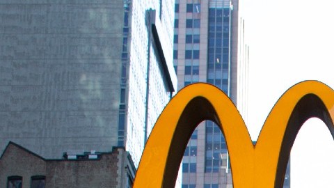 Imagen del logotipo de la cadena de restaurantes de comida rápida McDonald's, sujeta a un muro de cristal.
