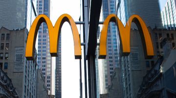 Imagen del logotipo de la cadena de restaurantes de comida rápida McDonald's, sujeta a un muro de cristal.