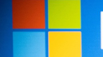 Imagen de un escenario de color azul, en el que se ve el logotipo de Microsoft y un teléfono celular con la leyenda ChatGPT.