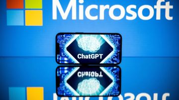 Imagen de un escenario de color azul, en el que se ve el logotipo de Microsoft y un teléfono celular con la leyenda ChatGPT.