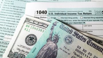 Imagen de varios formularios para declarar impuestos y de un cheque de reembolso, así como de un billete de $100 dólares.