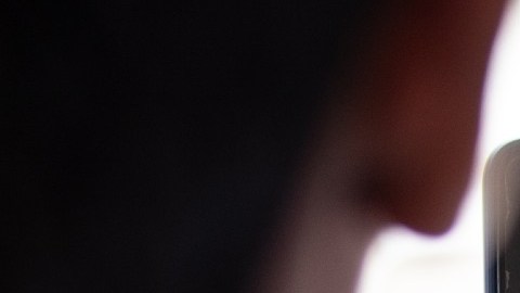 Imagen de una persona que sostiene un teléfono con la mano y en cuya pantalla se ve un logotipo de la red social TikTok.