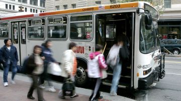 Imagen de personas fuera de foco mientras suben a un autobús de transporte público.