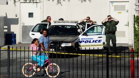 BELL, CA - JULY 26: Police officers from the neighboring City of Whittier responding on a mutual aid call to City of Bell look at crowds lined up to enter the community center calling for the ouster of city officials during a council meeting on July 26, 2010 in Bell, California. The council members have voted to cut their salaries in response to public outcry at city officials' high salaries. (Photo by Kevork Djansezian/Getty Images)