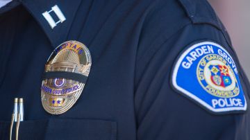 A police officer wears a badge with a mourning band during a press conference on August 8, 2019 in front of the Garden Grove Police Department after a series of stabbings and robberies in which six people were stabbed, four of them fatally, at multiple locations in Garden Grove and Santa Ana, California. - Police said the suspect, Zachary Castaneda, a 33-year-old resident of Garden Grove used multiple knives or machetes in the attacks that started yesterday afternoon. (Photo by Apu Gomes / AFP) (Photo credit should read APU GOMES/AFP via Getty Images)