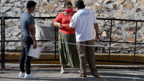 Un agente del INM de México da instrucciones a inmigrantes cubanos en Ciudad Juárez.