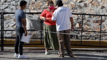 Un agente del INM de México da instrucciones a inmigrantes cubanos en Ciudad Juárez.
