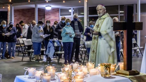 Bishop David O'Connell looks at candles placed on an altar representing people who lost their lives during the coronavirus pandemic, during a non-denominational memorial service to provide a space for community members who have lost loved ones in 2020 at the Saint Cornelius Catholic Church in Long Beach, California on November 14, 2020. - After California passed 1 million coronavirus cases a travel advisory was issued on November 13 urging a two-week quarantine for those arriving from other states or countries. (Photo by Apu GOMES / AFP) (Photo by APU GOMES/AFP via Getty Images)