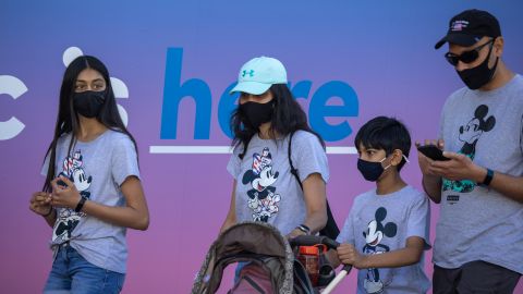 ANAHEIM, CA - APRIL 30: People enter Disneyland Park as it reopens for the first time since the COVID 19 pandemic forced the park to shut down last year on April 30, 2021 in Anaheim, California. California saw some of the highest infection rates in the nation over the winter but now enjoys some of the lowest. Los Angeles County, for example, is now expected to move from the orange tier of the states economic reopening system based on COVID-19 metrics to the least restrictive yellow tier, which would allow greater reopening freedoms, as early as next week. (Photo by David McNew/Getty Images)