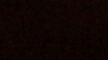 A visitor warms up herself with a candle in a studio named Ram, for its Indian owner, in Kyiv on December 20, 22022. - The women filed into the yoga studio, on the ground floor of an otherwise pitch-black apartment block, for an afterwork session that was specially tailored to Ukraine's current period of deprivation. (Photo by Sergei SUPINSKY / AFP) (Photo by SERGEI SUPINSKY/AFP via Getty Images)