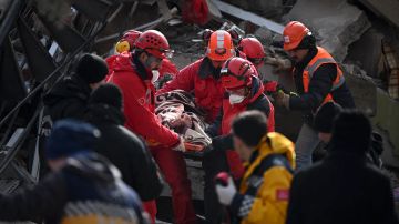 El personal de rescate lleva a un joven en una camilla a través de los escombros de los edificios en Kahramanmaras, el epicentro del terremoto.