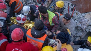 Rescatistas trasladan a una ambulancia a una mujer que sacaron de los escombros en Turquía.
