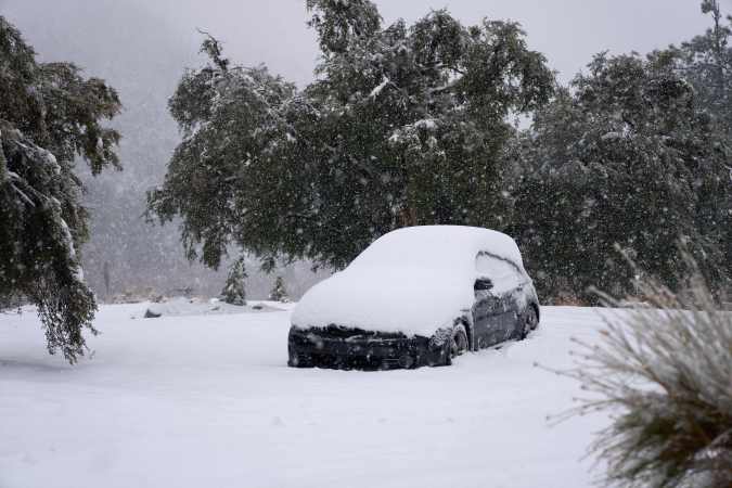 A car is covered in heavy snow in the town of Mount Baldy, California, on February 24, 2023. - Californians more used to flip flops and shorts were wrapping up warm Thursday as a rare winter blizzard, the first in more than 30 years, loomed over Los Angeles, even as the US East Coast basked in summer-like temperatures. (Photo by Allison Dinner / AFP) (Photo by ALLISON DINNER/AFP via Getty Images)