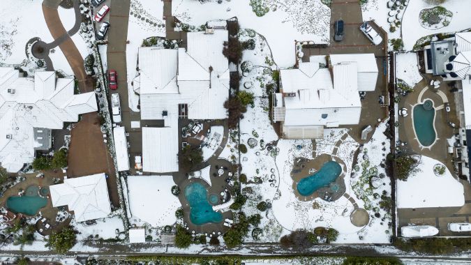 Snow covers homes in the Haven Estates neighborhood of Rancho Cucamonga, California, on February 25, 2023. - Heavy snow fell in southern California as the first blizzard in a generation pounded the hills around Los Angeles, with heavy rains threatening flooding in other places. (Photo by JOSH EDELSON / AFP) (Photo by JOSH EDELSON/AFP via Getty Images)