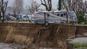 TOPSHOT - An RV begins to fall into the Santa Clara River as the ground bellow it is washed away by flooding due to heavy rain washing away over 150 feet of land and multiple RV homes in Castaic, California, on February 25, 2023. - A major storm with a blizzard warning for parts of Southern California is expected to deliver damaging rain and snow at elevations lower than normal in Los Angeles County. (Photo by Allison Dinner / AFP) (Photo by ALLISON DINNER/AFP via Getty Images)