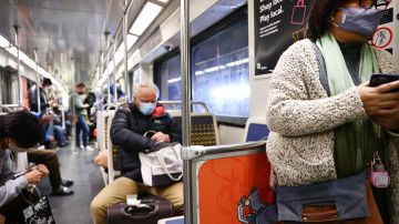 LOS ANGELES, CALIFORNIA - DECEMBER 15: People wear face coverings while riding a Los Angeles Metro Rail train on December 15, 2021 in Los Angeles, California. California residents, regardless of COVID-19 vaccination status, are required to wear face masks in all indoor public settings beginning today in response to rising coronavirus case numbers and the omicron threat. The statewide mandate will be in effect through January 15, 2022. (Photo by Mario Tama/Getty Images)