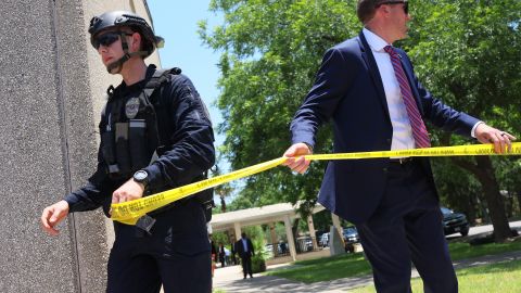 UVALDE, TEXAS - MAY 28: Law enforcement officials put up caution tape as President Joe Biden attends mass at Sacred Heart Catholic Church on May 29, 2022 in Uvalde, Texas. On May 24th, 19 children and two adults were killed during a mass shooting at Robb Elementary School after a gunman entered the school through an unlocked door and barricaded himself in a classroom where the victims were located. (Photo by Michael M. Santiago/Getty Images)