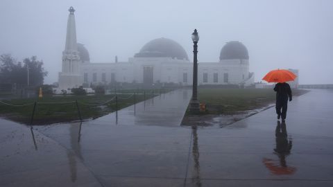 LOS ANGELES, CALIFORNIA - FEBRUARY 24: A person walks in the rain at Griffith Observatory on February 24, 2023 in Los Angeles, California. A major storm, carrying a rare blizzard warning for parts of Southern California, has begun to deliver heavy snowfall to the mountains with some snowfall expected to reach lower elevations in Los Angeles County. (Photo by Mario Tama/Getty Images)