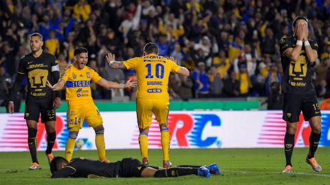 Jugadores de Tigres celebran una anotación a Pumas.