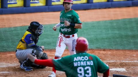 Irvin López (c) de Cañeros de Mochis anota una carrera contra los Vaqueros de Montería de Colombia.